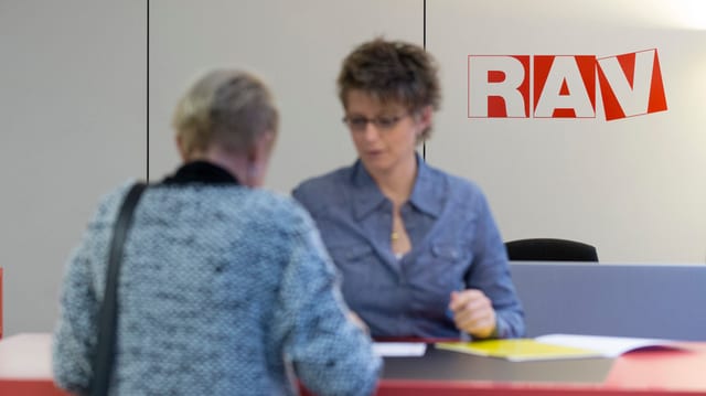 Eine Frau spricht mit einer anderen Frau vor dem Schriftzug RAV Eine Frau spricht mit einer anderen Frau vor dem Schriftzug RAV