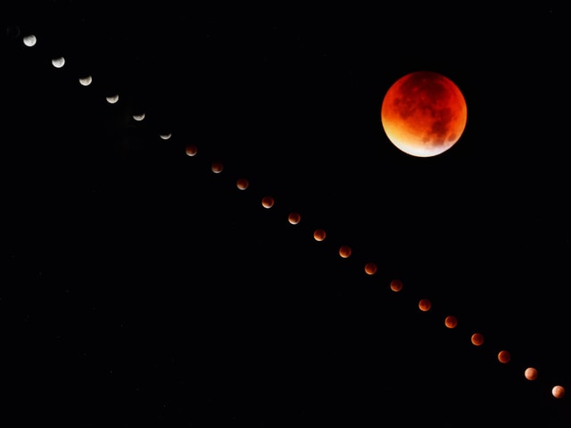 Nachthimmel mit grossem roten Vollmond.