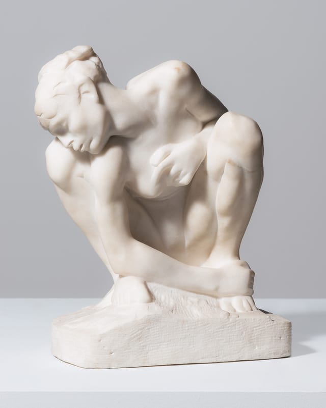 Skulptur einer kauernden Person.