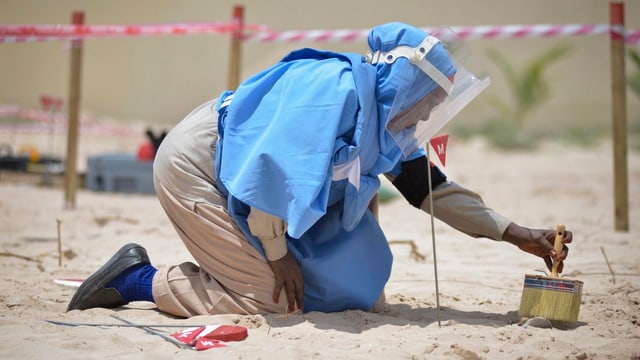 Eine Person beim Entschärfen einer Landmine. Eine Person beim Entschärfen einer Landmine.