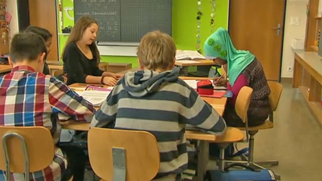 Schülerin mit Kopftuch inmitten anderer Schüler. Schülerin mit Kopftuch inmitten anderer Schüler.