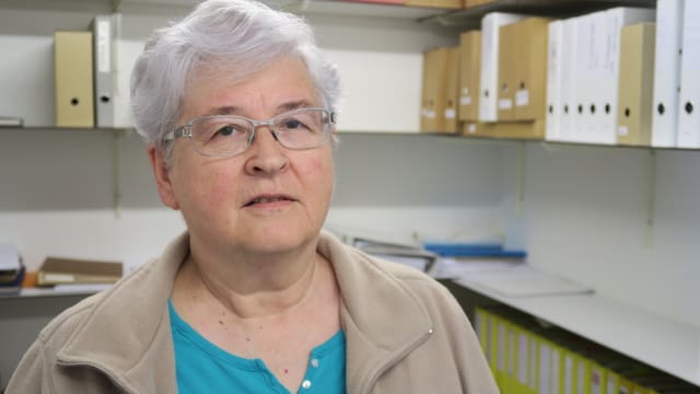 Frau in Raum mit Ordnern Frau in Raum mit Ordnern