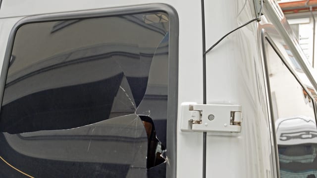 Ein Polizeiauto mit eingeschlagener Scheibe. Ein Polizeiauto mit eingeschlagener Scheibe.