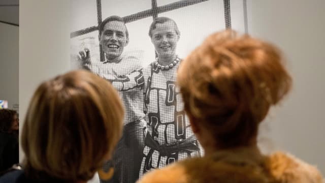 Zwei Frauen stehen vor einem schwarz-weiss Bild von zwei Menschen Zwei Frauen stehen vor einem schwarz-weiss Bild von zwei Menschen