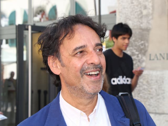 Ein Mann mit weissem Hemd, blauem Jackett, dunklen Haaren. Ein Mann mit weissem Hemd, blauem Jackett, dunklen Haaren.