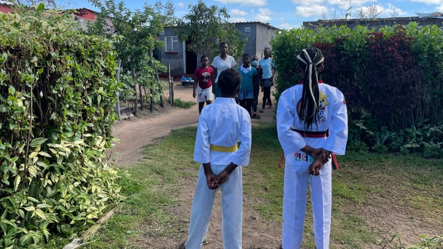 Zwei Taekwondo-Schüler von hinten auf Rasen Zwei Taekwondo-Schüler von hinten auf Rasen
