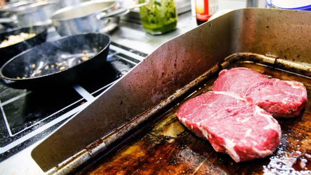 2 Steaks werden in der Kantineküche angebraten 2 Steaks werden in der Kantineküche angebraten