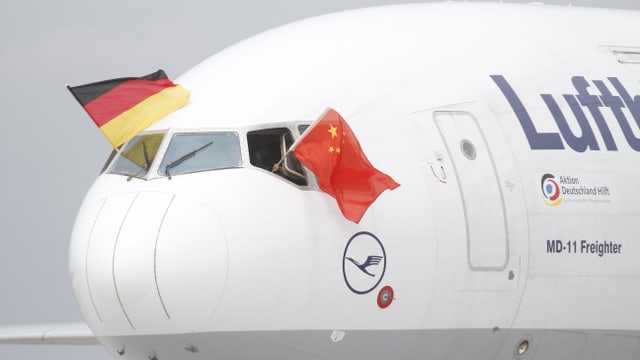 Zwei Piloten der Frachtmaschine schwenken die deutsche und die chinesische Flagge. Zwei Piloten der Frachtmaschine schwenken die deutsche und die chinesische Flagge.