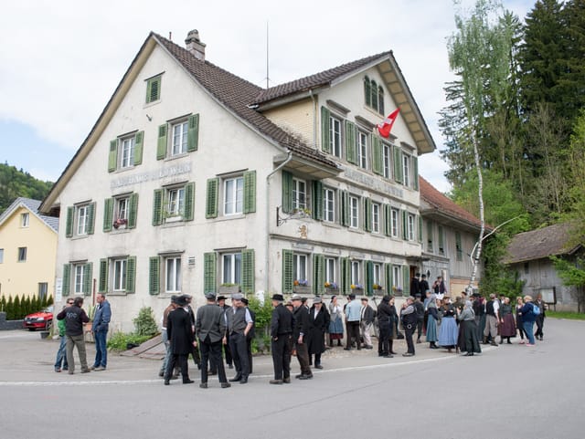 Statisten vor Gasthaus Löwen, in Gruppen, am schwatzen