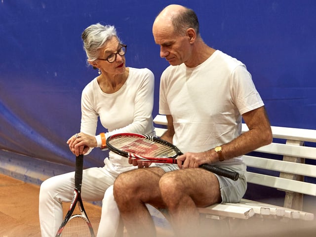 Paar auf Bank in Tenniskluft Paar auf Bank in Tenniskluft