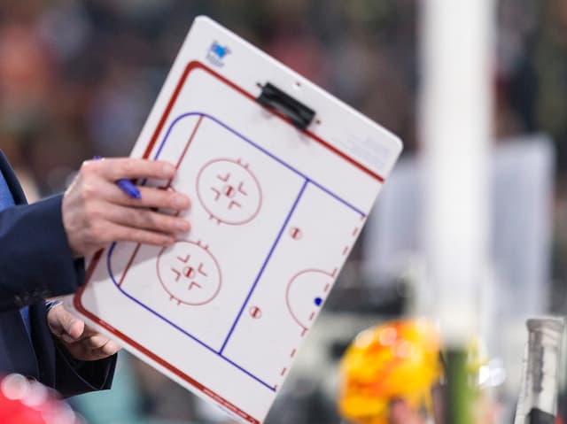 Ein Trainer hält eine Spielfeldmappe Ein Trainer hält eine Spielfeldmappe
