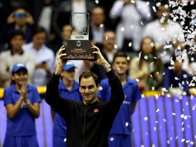 Federer posiert mit einer Trophäe. Federer posiert mit einer Trophäe.