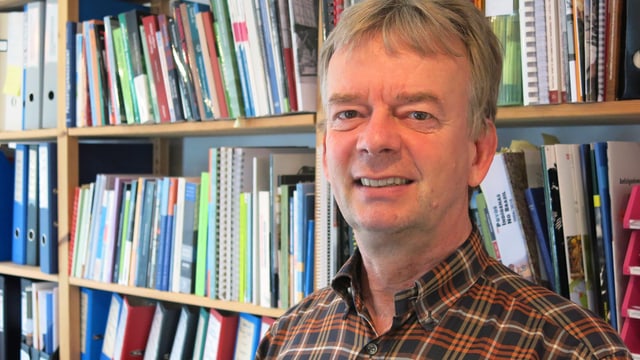Porträt von Christoph Wiedmer vor einem Bücherregal. Porträt von Christoph Wiedmer vor einem Bücherregal.