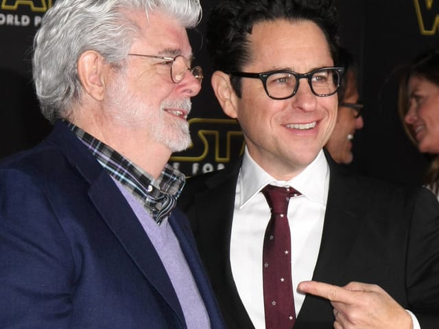 George Lucas und JJ Abrams auf dem Roten Teppich. Letzterer zeigt andächtig mit dem Finger auf sein Vorbild Lucas. George Lucas und JJ Abrams auf dem Roten Teppich. Letzterer zeigt andächtig mit dem Finger auf sein Vorbild Lucas.