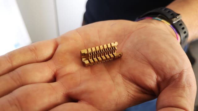 Sehr kleines Metallteil auf einer Handfläche Sehr kleines Metallteil auf einer Handfläche