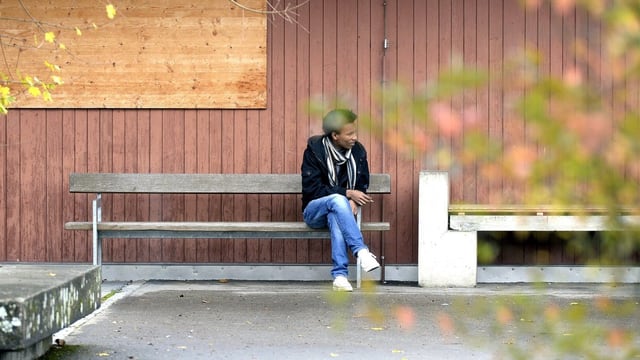Symbolbild Asylunterkunft. Ein Mann sitz vor einer Asylunterkunft auf einer Bank. Symbolbild Asylunterkunft. Ein Mann sitz vor einer Asylunterkunft auf einer Bank.