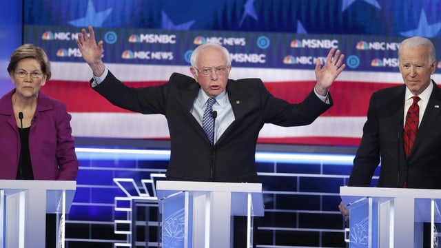Elizabeth Warren und Bernie Sanders stehen neben Joe Biden Elizabeth Warren und Bernie Sanders stehen neben Joe Biden
