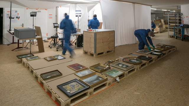 In Schutzanzügen und mit Atemmasken reinigen Mitarbeiter Bilder. In Schutzanzügen und mit Atemmasken reinigen Mitarbeiter Bilder.