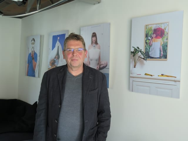 Mann steht vor Wand mit Bildern Mann steht vor Wand mit Bildern