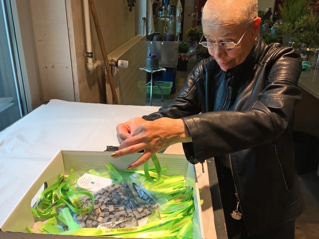 Mit viel Fingerspitzengefühl montiert eine Wagerenhof-Bewohnerin graue Clips an die knallgrünen Festival-Bändel. Mit viel Fingerspitzengefühl montiert eine Wagerenhof-Bewohnerin graue Clips an die knallgrünen Festival-Bändel.