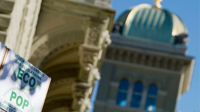 Im Vordergrund ein Ecopop-Plakat (Initiative), im Hintergrund das Bundeshaus. Im Vordergrund ein Ecopop-Plakat (Initiative), im Hintergrund das Bundeshaus.