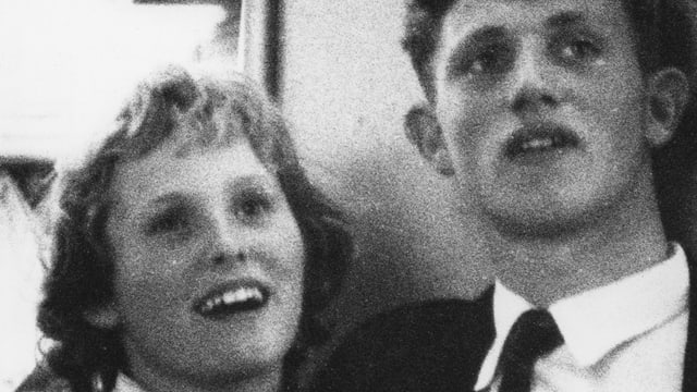 Ein Mann und eine Frau lächeln auf einem grobkörnigen SchwarzWeissbild in die Kamera. Ein Mann und eine Frau lächeln auf einem grobkörnigen SchwarzWeissbild in die Kamera.