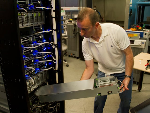 Mann schiebt einen Server ein ein Rack. Mann schiebt einen Server ein ein Rack.