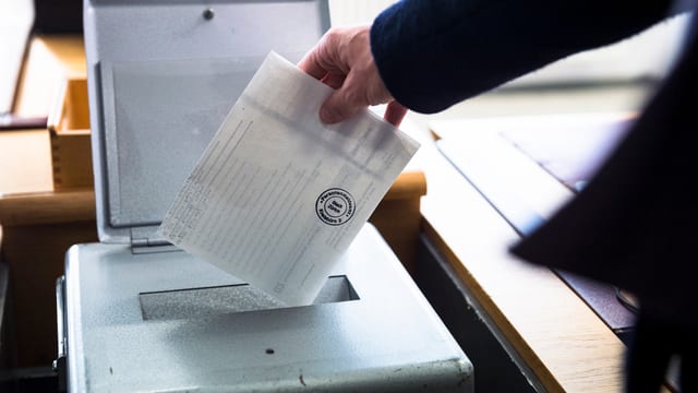 Mann wirf Wahlzettel in eine Urne. Mann wirf Wahlzettel in eine Urne.