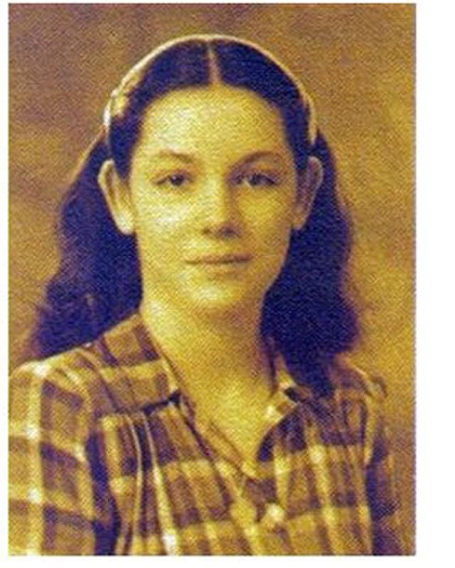 Foto in Sepia-Farbton. Nana trägt langes, lockiges Haar mit Mittelscheitel, welches von einem Haarreif in Zaum gehalten wird. Foto in Sepia-Farbton. Nana trägt langes, lockiges Haar mit Mittelscheitel, welches von einem Haarreif in Zaum gehalten wird.