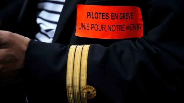 Arm eines Piloten in Uniform mit Streik-Spruch. Arm eines Piloten in Uniform mit Streik-Spruch.