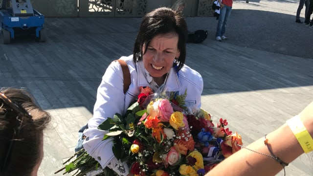 Frau mit dunklen Haaren und weisser Jeansjacke und Blumenstrauss Frau mit dunklen Haaren und weisser Jeansjacke und Blumenstrauss