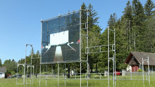 An einem Gerüst in einer grosse Fotografie angebracht. An einem Gerüst in einer grosse Fotografie angebracht.