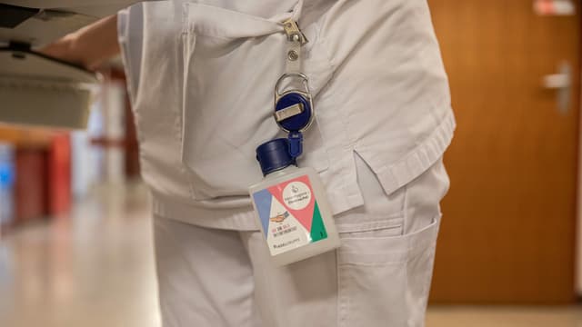 Ein Desinfektionsmittel hängt an einem Badge. Ein Desinfektionsmittel hängt an einem Badge.