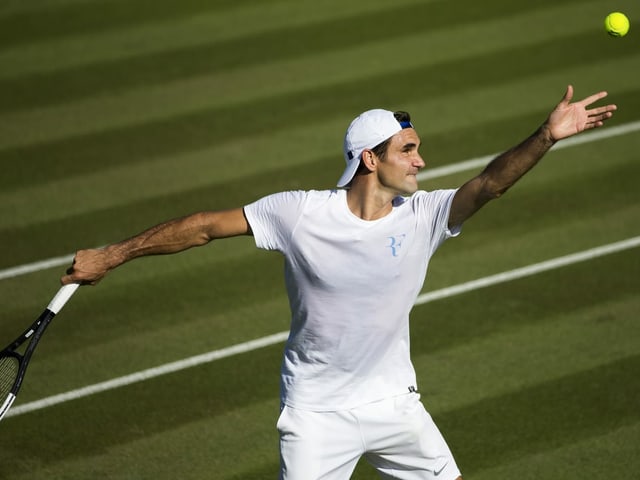 Roger Federer schlägt im Rasentraining auf.