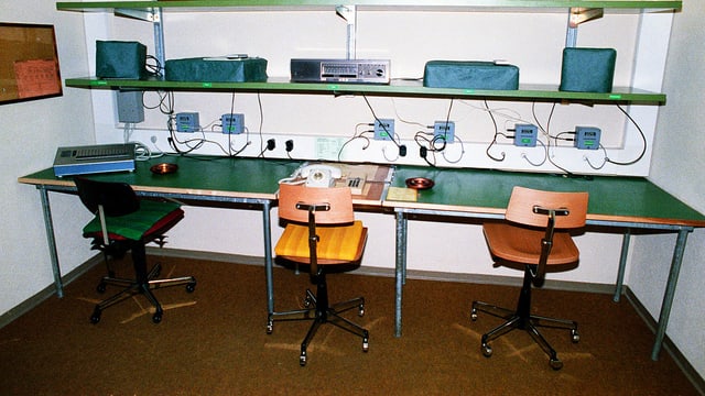 Arbeitsraum in einer unterirdischen Bunkeranlage der Geheimarmee P-26 bei Gstaad: Stühle, Telefone und ein grüner Tisch. Arbeitsraum in einer unterirdischen Bunkeranlage der Geheimarmee P-26 bei Gstaad: Stühle, Telefone und ein grüner Tisch.