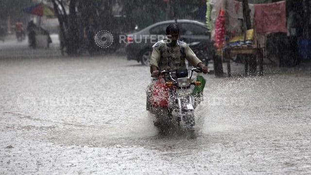 um che va cun moped tras via inundada a pakistan um che va cun moped tras via inundada a pakistan