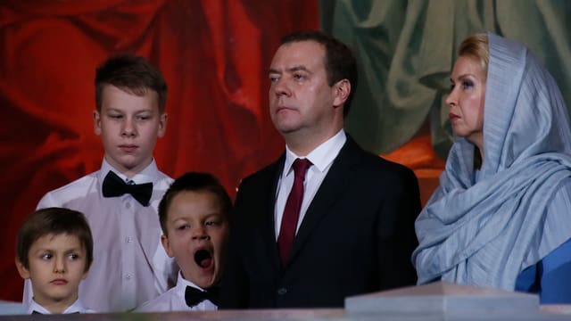 Familie Medwedew beim Gottesdienst, ein Sohn gähnt. Familie Medwedew beim Gottesdienst, ein Sohn gähnt.