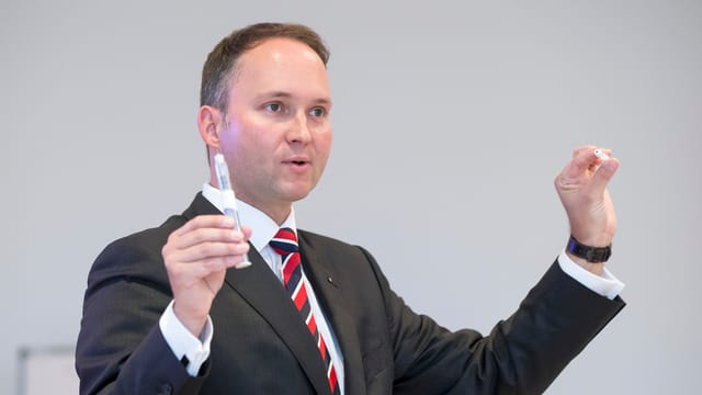Mann hält kleine Geräte in den Händen und präsentiert sie. Mann hält kleine Geräte in den Händen und präsentiert sie.