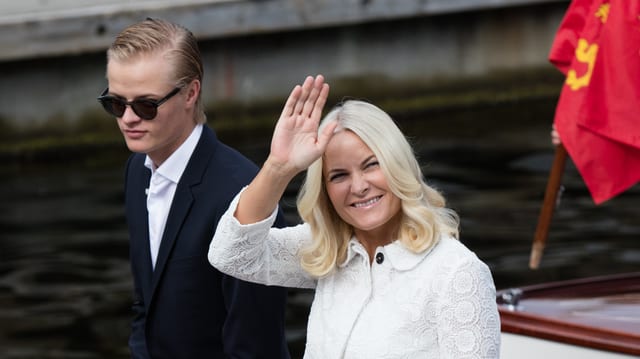 Marius Borg Høiby mit Sonnenbrille und Anzug, Mette-Marit im weissen Mantel. Marius Borg Høiby mit Sonnenbrille und Anzug, Mette-Marit im weissen Mantel.
