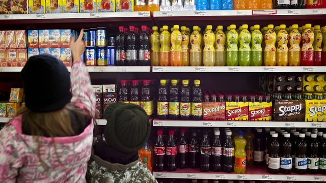 Kinder vor einem Regal voller Süssgetränke Kinder vor einem Regal voller Süssgetränke