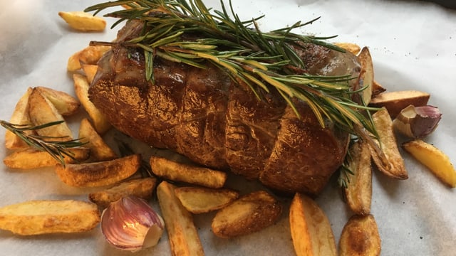 Ein Roastbeef mit Bratkartoffeln, garniert mit einem Rosmarin-Zweig. Ein Roastbeef mit Bratkartoffeln, garniert mit einem Rosmarin-Zweig.