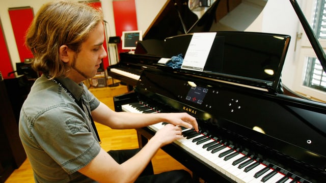 Ein Mann sitzt an einem E-Klavier und spielt. Ein Mann sitzt an einem E-Klavier und spielt.