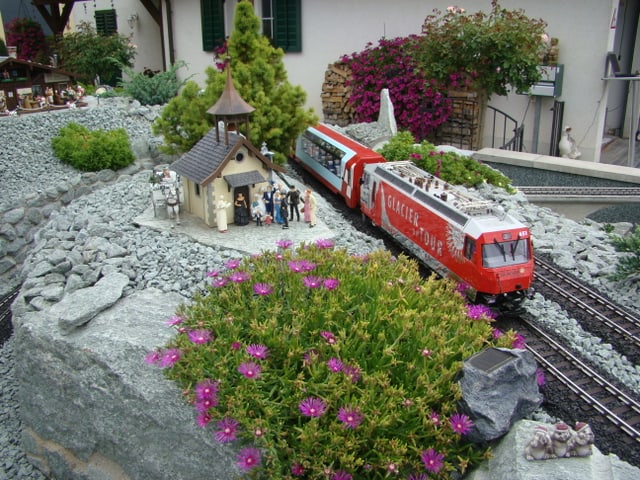 Modelleisenbahnanlage mit einer Hochzeitsszene vor einer kleinen Kapelle.