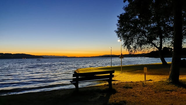 Blick über den Murtensee von Avenches aus mit einem zarten Morgenrot über dem See. Blick über den Murtensee von Avenches aus mit einem zarten Morgenrot über dem See.