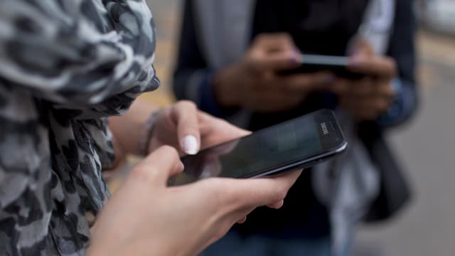 Junge Frauen tippen auf ihrem Handy. Junge Frauen tippen auf ihrem Handy.