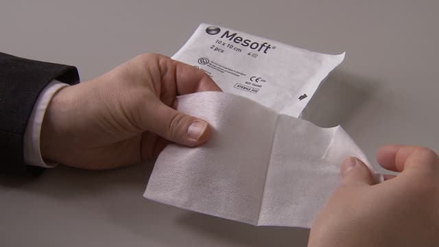 Ein Mann hält eine Kompresse in seinen Händen. Ein Mann hält eine Kompresse in seinen Händen.