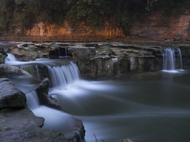 Ein Wasserfall bei Sonnenuntergang.