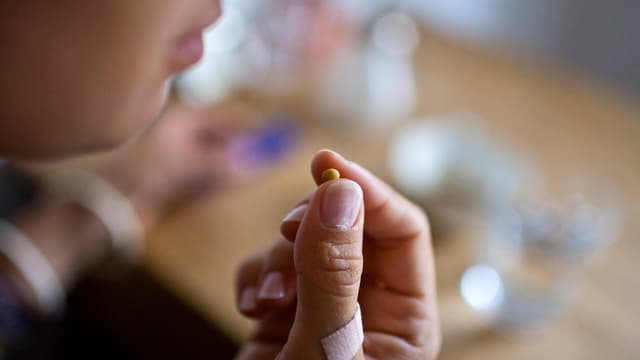 Eine Frau nimmt eine Anti-Baby-Pille zu sich. 