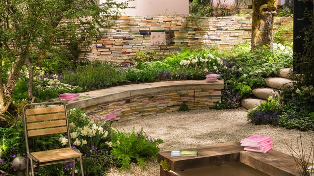 Ein Garten mit Mauern aus Büchern und einem kleinen Teich in der Mitte. Ein Garten mit Mauern aus Büchern und einem kleinen Teich in der Mitte.