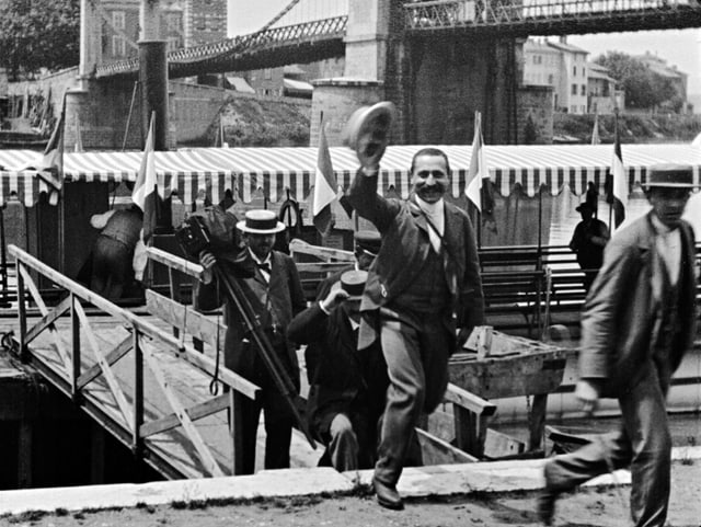 Schwarz-Weiss-Bild: Leute steigen über eine Brücke auf das Festland. Schwarz-Weiss-Bild: Leute steigen über eine Brücke auf das Festland.